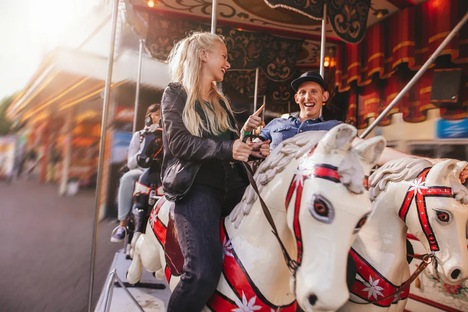 An adult and child smiling on a carousel