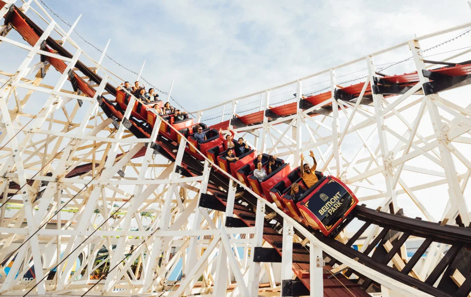 Riders aboard the Giant Dipper wooden coaster at Belmont Park in San Diego