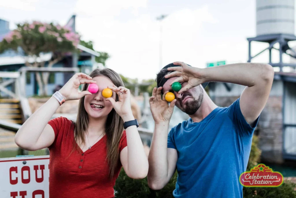 Visitors holding colorful golf balls at Celebration Station Mesquite