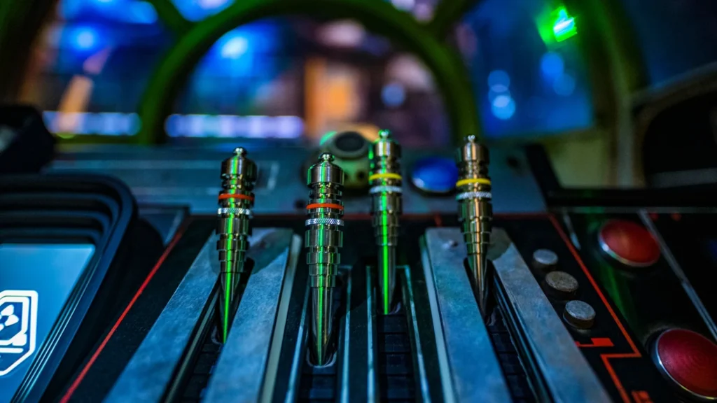 Four metal control levers and colored buttons inside the Millennium Falcon cockpit.