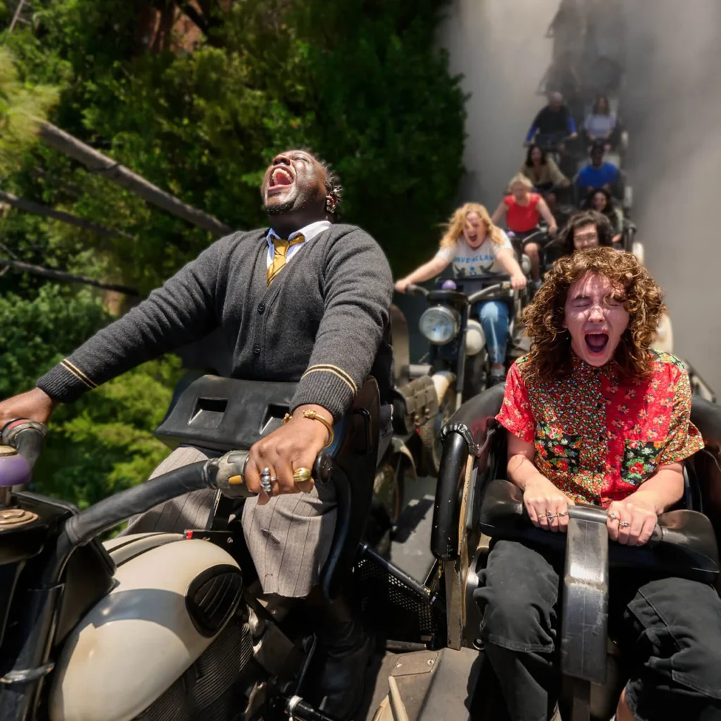 Guests ride motorcycle-style vehicles through a wooded setting on Hagrid’s Magical Creatures Motorbike Adventure at Islands of Adventure.