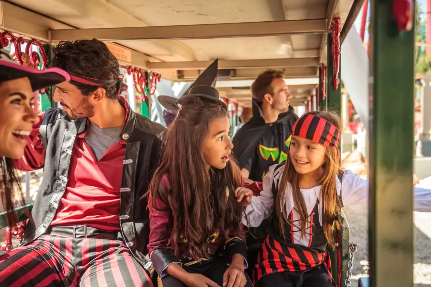 Children in Halloween costumes sit together on a train at Knott’s Spooky Farm.