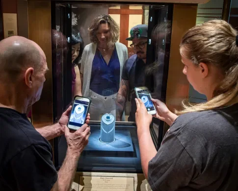 Visitors use phones to photograph the Hope Diamond in its display case at the Smithsonian National Museum of Natural History.