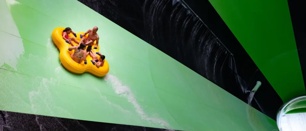 Raft riders on the green Alien Invasion water slide at Splish Splash