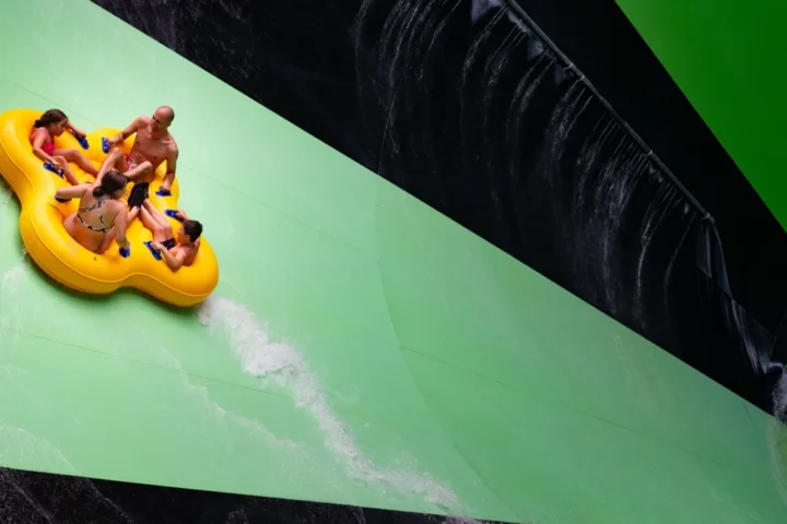 Raft riders on the green Alien Invasion water slide at Splish Splash