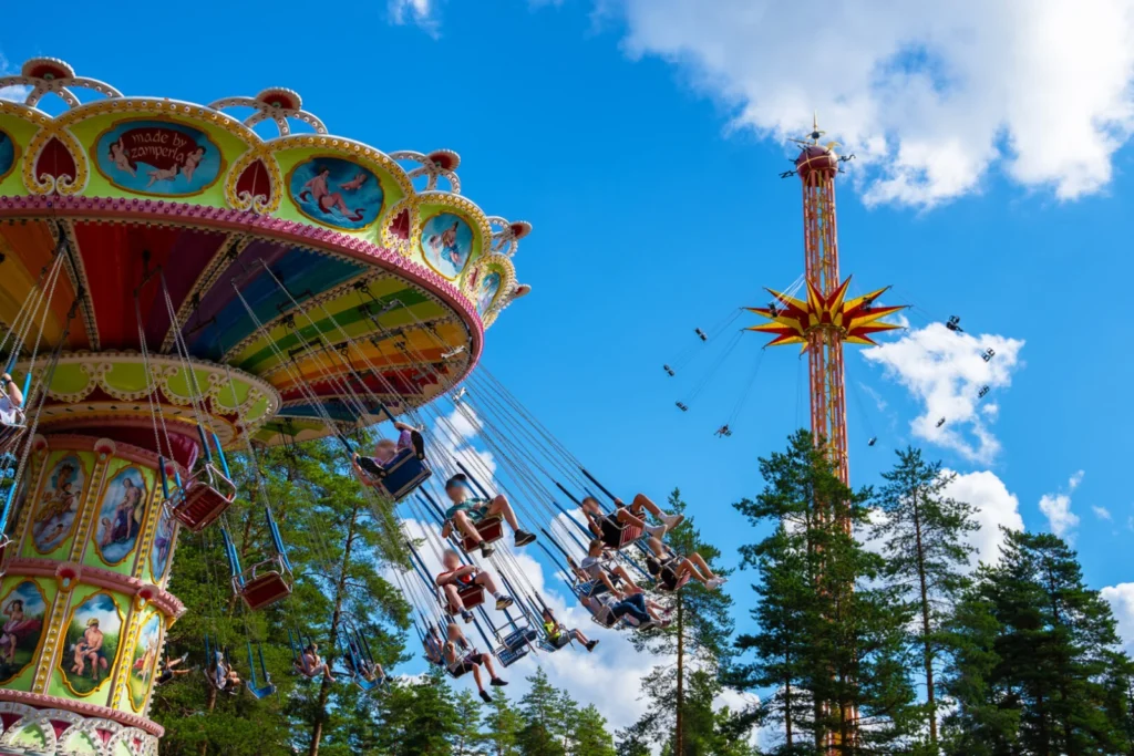 Swing rides beneath a blue sky at Tykkimäki in Kouvola