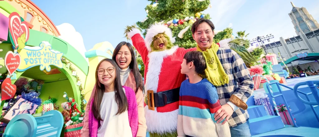 A family poses with the Grinch beside the decorated Whoville tree during Grinchmas at Universal Studios Hollywood.