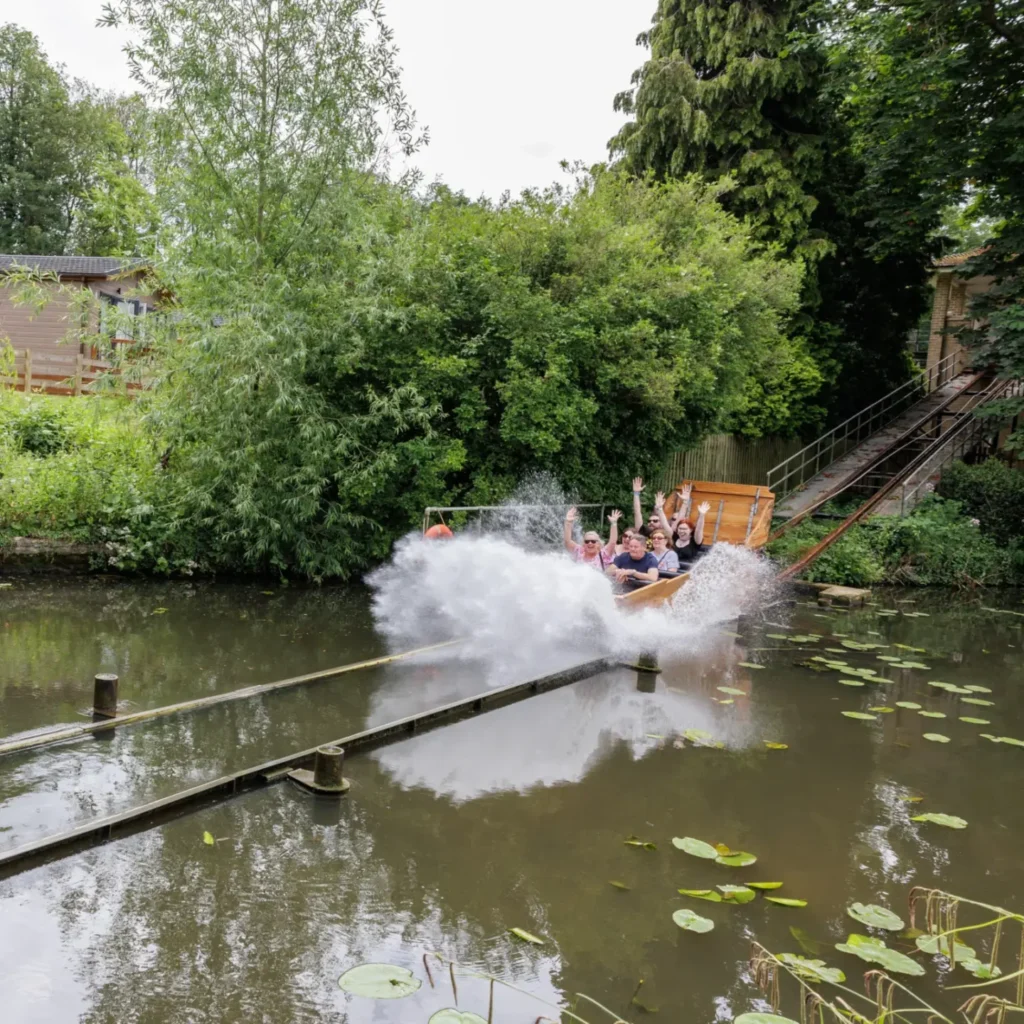Riders splashing into the lake on the historic Water Chute at Wicksteed Park